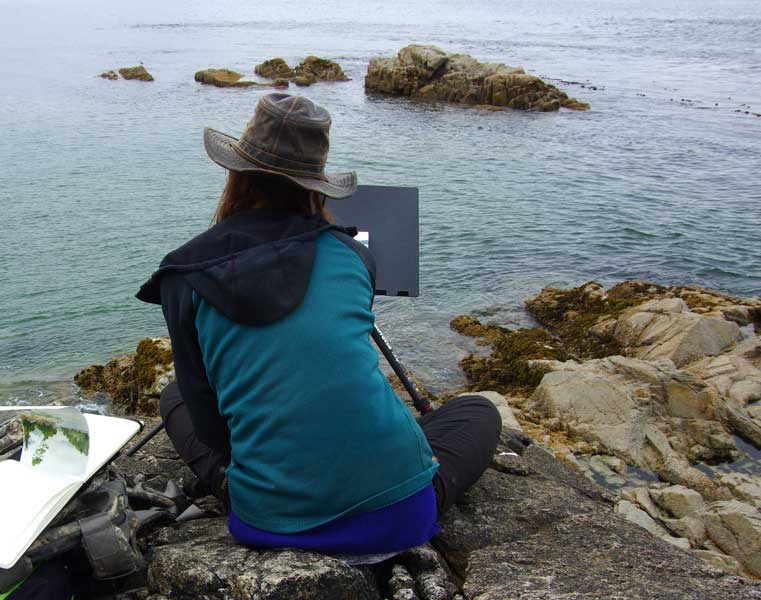 Photograph of Jessica Lanan sketching the ocean in Vancouver Island.