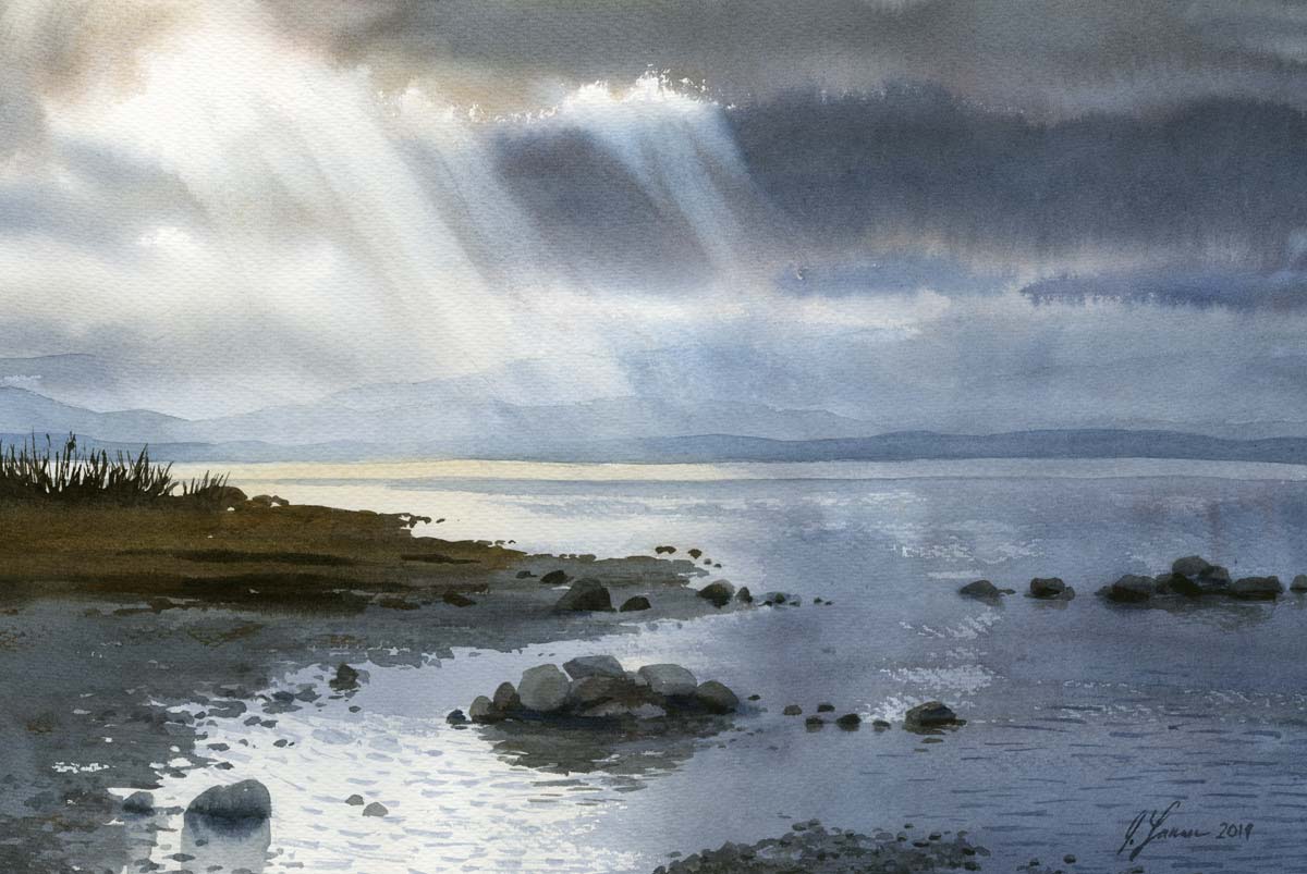 Watercolor painting of a lake with rocks and foliage in the foreground. Sunbeams break through the gray clouds in the sky, illuminating the water in the distance.
